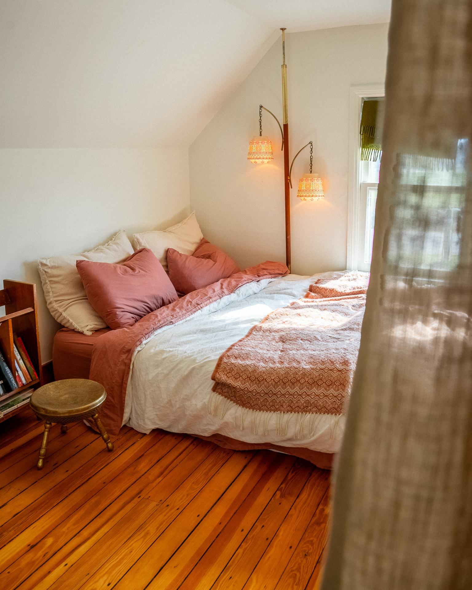 Cozy bedroom with sloped ceilings and hanging lamps