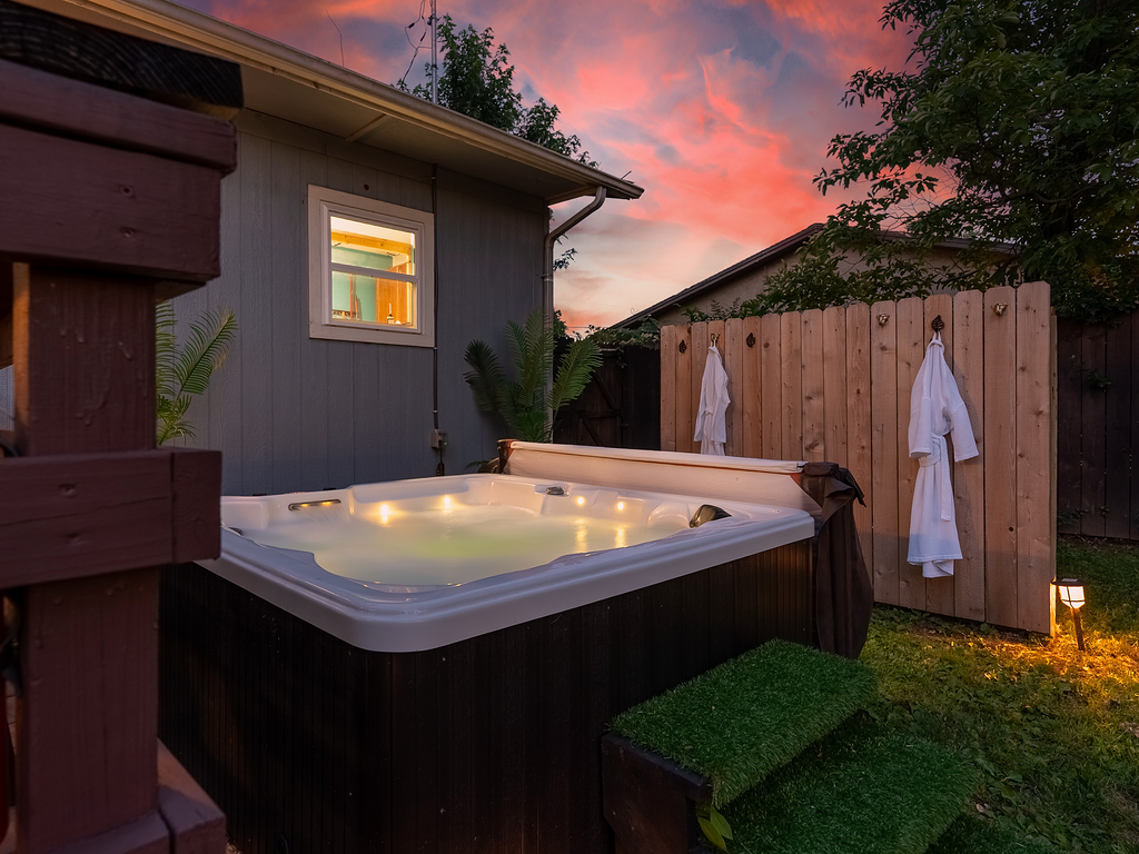 Backyard hot tub glowing at dusk