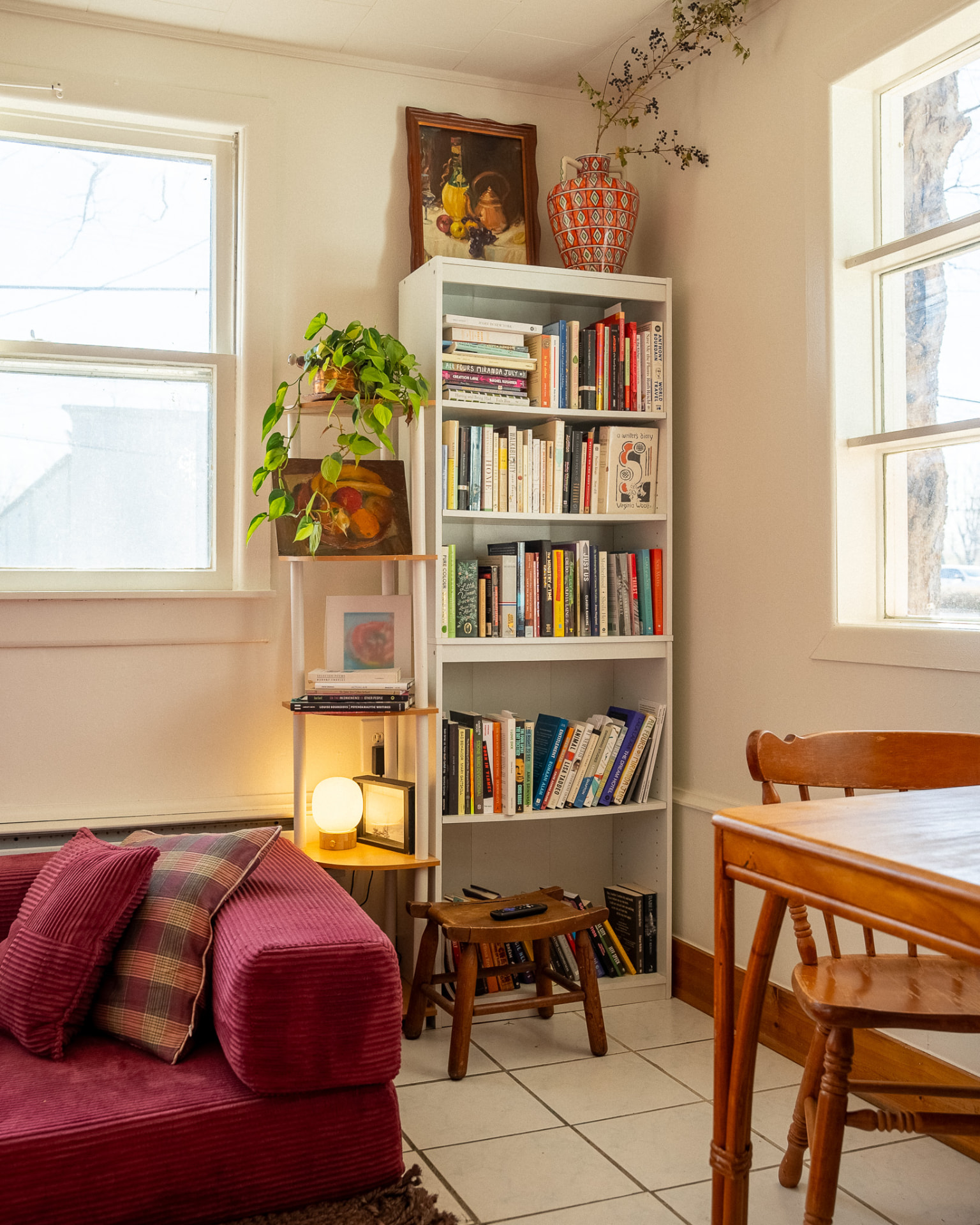 Corner bookshelf with plants and framed art