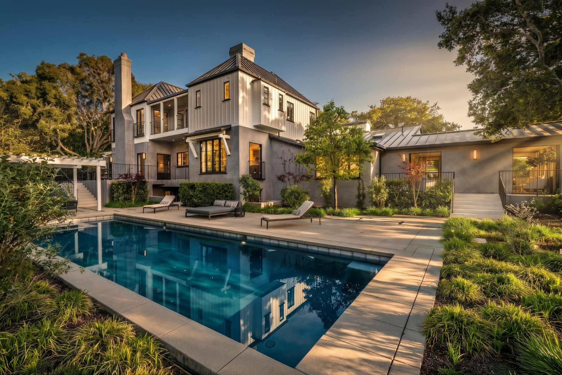 Twilight exterior photograph of a luxury home with pool