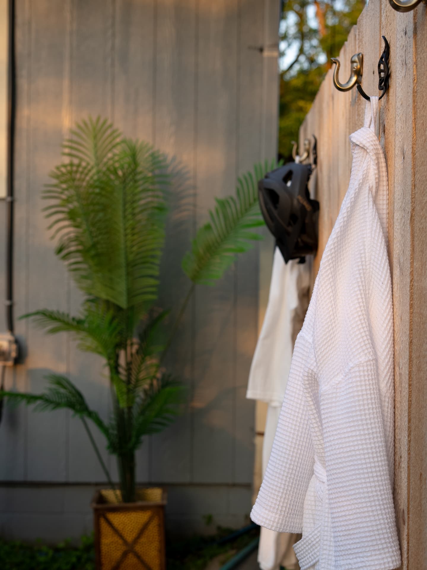 Outdoor hooks with robes at a Bentonville rental during golden hour